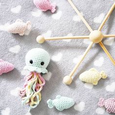 there are crocheted sea animals on the floor next to an umbrella with wooden sticks