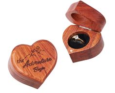 a wooden ring box with an engraved heart and the words, the adventure begins on it