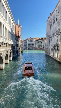 a boat traveling down a river next to tall buildings and water bridges in venice, italy