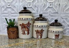 three ceramic canisters sitting on top of a counter