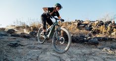 a man riding a mountain bike down a rocky slope