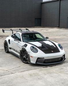 a white and black sports car parked in front of a building