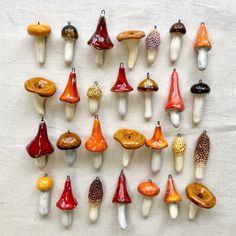 a group of different colored glass mushrooms on a white tablecloth with the tops turned upside down