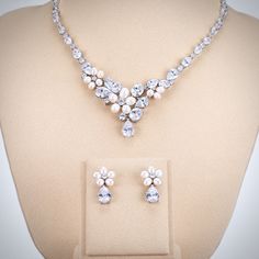 A beautiful two-piece bridal jewelry set with an incredible sparkle! Adorned with iridescent natural pearls and intricately faceted cubic zirconia that capture the light from every angle with a perfectly translucent appeal, the pieces are rhodium/rose gold plated for a flawless finish which enhances the intricate detailing and conveys a modern take on old elegance. Necklace: 17.5" long (approx. 45cm) with a secure fold-over clasp. Earrings: measure 1" (approx. 26mm) long and come with sturdy bac Silver Pearl Bridal Sets For Formal Occasions, Formal Silver Pearl Bridal Sets, Elegant Pearl Bridal Sets With Pearl Drop, Formal Pearl Drop Jewelry Sets With Cubic Zirconia, Wedding Jewelry With Pearl And Diamond Accents, Anniversary Jewelry Sets With Pearl Drop And Cubic Zirconia, Wedding Pearl Necklace With Diamond Accents, Pearl Necklace With Diamond Accents For Wedding, White Gold Pearl Necklace With Cubic Zirconia For Wedding