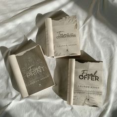 three books laying on top of a bed next to each other