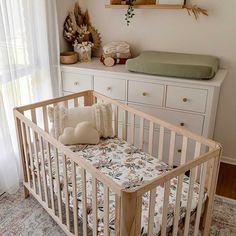 a baby's crib in the corner of a room next to a dresser