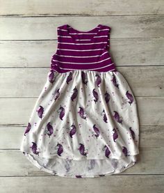 Welcome to Busy Bee Stitchery! This one of a kind 5T high-low dress will delight the little girl in your life. This dress is made from soft French Terry knit.  This dress will be a lovely addition to any little girl's wardrobe.  Pair it with a cute pair of leggings and boots!    All items are handmade by me in my smoke free, pet free studio, with love and attention to detail. All fabrics are prewashed and preshrunk before production. Since the fabrics are preshrunk you don't need to worry about them shrinking in the wash.   Recommended care of items is to machine wash on cold and tumble dry on low. Do not wash with heavy materials like jeans and towels. CPSC Compliant Become a Facebook fan here:  https://www.facebook.com/busybeestitcheryhandmade/ Follow us on Instagram at @busy.bee.stitche Playful Purple Sleeveless Dress, Cute Purple Sleeveless Dress, Fun Sleeveless Cotton Twirl Dress, Sleeveless Unicorn Print Dress For Spring, Whimsical White Sleeveless Dress, Pink Sleeveless Dress With Unicorn Print, Casual White Sleeveless Twirl Dress, Playful Sleeveless Unicorn Print Dress, Playful Summer Dresses With Unicorn Print