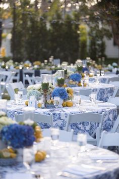 tables with blue and white tablecloths are set up for an outdoor wedding reception