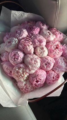 a bunch of pink flowers sitting on top of a car seat