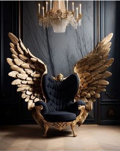 an ornate chair with gold wings in front of a chandelier hanging from the ceiling