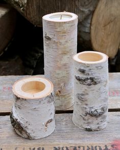 three white birch logs sitting on top of a wooden table