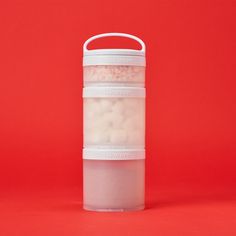 two plastic containers filled with white balls on a red background