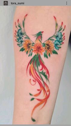 a colorful tattoo with flowers on the side of her leg and an orange flower in the center