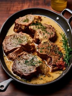 some steaks are cooking in a skillet