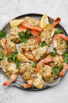 shrimp and crab cakes with lemon wedges on a platter, ready to be eaten