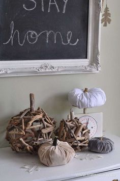 a chalkboard with the words stay home written on it next to two pumpkins