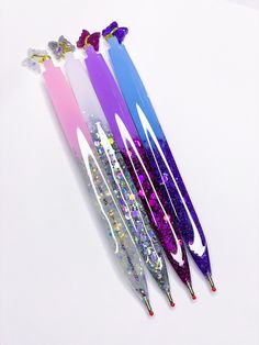 four different colored arrows with glitter on them