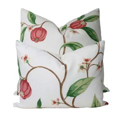 two white pillows with red flowers and green leaves on the front one has a pink flower