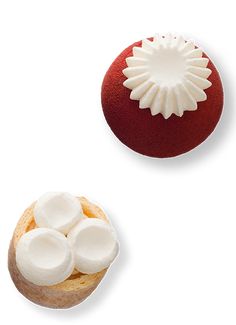 two pastries with white icing on them sitting next to each other in front of a red ball