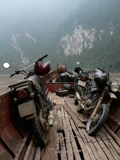 two motorcycles are parked on the back of a boat