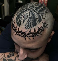 a man with tattoos on his head wearing a crown of barbed wire