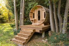 an outdoor sauna in the woods with steps leading up to it