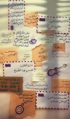 several pieces of paper with arabic writing on them and envelopes attached to the wall