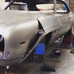 an old car being worked on in a garage