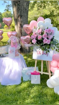 pink and white balloons are on display in the grass