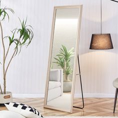 a large mirror sitting on top of a wooden floor next to a lamp and chair