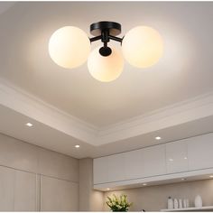 three lights are hanging from the ceiling above a kitchen counter