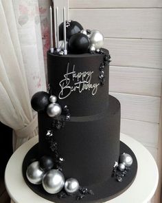 a three tiered black and silver birthday cake