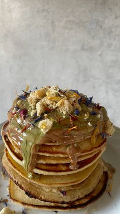 a stack of pancakes covered in frosting and sprinkles