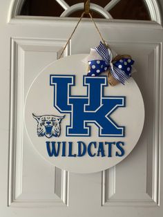 a kentucky wildcats sign hangs on the front door with polka dots and a blue bow