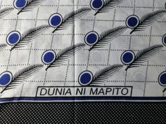 a blue and white table cloth with peacocks on it, the words duna ni mapto written in black ink