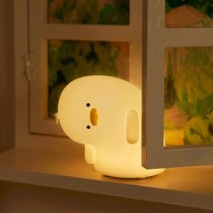 an elephant shaped light sitting on top of a shelf next to a window sill