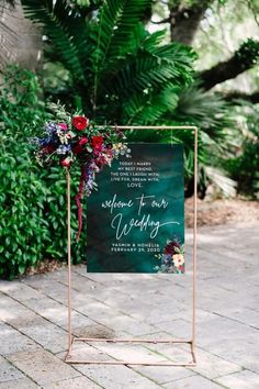 a sign that says welcome to our wedding with flowers and greenery on the side