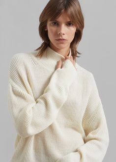 Color: Ecru Midweight wool blend fabric Relaxed fit Turtleneck Drop shoulders Rib knit Slip on style 50% Wool 50% Acrylic Dry Clean By Amomento. Imported White Textured Knit Cashmere Sweater, Beige Merino Wool Sweater With Textured Knit, White Fine Knit Cashmere Sweater, White Merino Wool Sweater For Fall, Beige Textured Knit Merino Wool Sweater, Beige Textured Merino Wool Sweater, Cream Knitted Sweater For Work, Classic White Knit Top For Fall, White Knit Top For Work In Winter