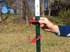 a hand is holding the top of a pole