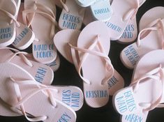 several pairs of pink flip flops with blue and white words on them, all tied together