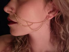 a woman with long blonde hair wearing a gold chain choker and earring set