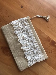 an old lace purse is sitting on a wooden floor with a tassel hanging from it's side