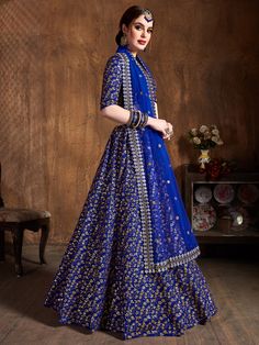 Featuring a stunning blue-colored bridal raw silk wedding lehenga, this ensemble is designed to make you the center of attention on any special occasion. Made from high-quality raw silk material, this lehenga is crafted with intricate zari work, sequin work, and heavy embroidery all over, adding a touch of elegance and grandeur.
Accompanied by a matching color choli, also made from a similar raw silk material, this ensemble is complete with the same zari work, sequin work, and heavy embroidery. Royal Blue Lehenga, Engagement Lehenga, Indian Bridesmaids, Raw Silk Lehenga, Wedding Dress Outfit, Saree Lehenga, Bollywood Lehenga, Raw Silk Fabric, Blue Lehenga