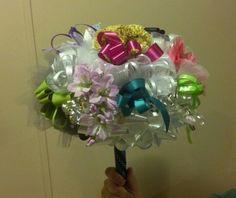 a person holding a bouquet with bows and ribbons on it's head in front of a door