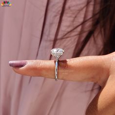 a woman's hand with a diamond ring on it