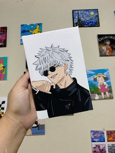 a hand holding up a piece of paper with an anime character drawn on it