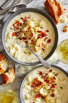 two bowls filled with soup next to bread