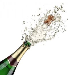 a bottle of champagne is being poured into the air with water splashing around it