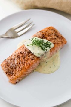 a piece of salmon on a plate with cream sauce