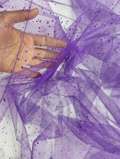 This is purple glitter on tulle. The fabric has shiny and sparkly look because of the glitter. The fabric serves multipurpose and can be used for dresses, gowns proms, decor, and many more.  PLEASE NOTE : Although there is no compromise with the quality of the fabric, some might notice falling off the GLITTER while handling, which is quite common with these kinds of fabric. CLR: Purple WIDTH: 60/62 INCHES                   LENGTH : 36 INCHES (1 YARD) CONTENT/COMPOSITION: Polyester 100% USAGE: Bridal & Wedding Dress, Evening Gowns, Partywear, Prom, Costume, Décor, Hair Accessories, Bags, DIY CARE INSTRUCTIONS:  Wash gently. Hand wash whenever possible. Avoid machine wash if you can. Wash items in cool water. Avoid extreme heat. If possible Dry Clean.  Please note image colors may vary per s Kinds Of Fabric, Gown Prom, Price Offer, Dress Gown, Purple Glitter, Bridal Wedding Dresses, Event Decor, Evening Gowns, Violet